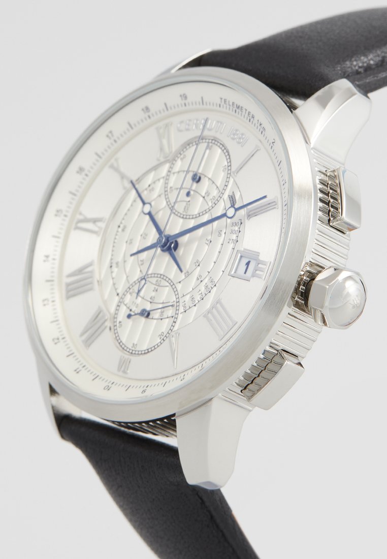 Montre chronographe argentée avec un cadran blanc, aiguilles bleues, chiffres romains et un bracelet en cuir noir. Dispose d'une lunette texturée et d'un affichage de la date.
