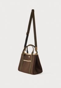 Καφέ υφασμάτινη τσάντα tote με δύο λαβές και ρυθμιζόμενη ανάρτηση ώμου, με μπεζ περιθώριο και μια μικρή μπροστινή τσέπη.