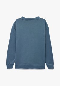 Sudadera de cuello redondo de manga larga en color azul liso, con puños y dobladillo acanalados, vista desde la parte trasera sobre un fondo blanco.