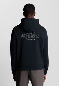 Felpa con cappuccio nera realizzata in tessuto morbido, con la scritta "LYLE ATHLETIC FUEL AMBITION" stampata in bianco sulla schiena. Tessuto liscio, design minimalista.