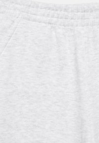 Light gray fabric sweatpants waistband with elastic and side pocket stitching visible.