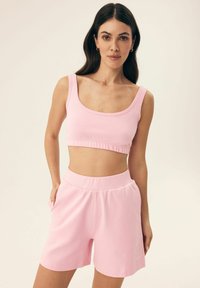 Różowy bawełniany crop top z kwadratowym dekoltem oraz pasującymi szortami z wysokim stanem, z elastycznym pasem i minimalistycznym logo.