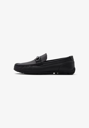 Black leather loafer, featuring a textured finish, decorative buckle, round toe, and flexible rubber sole for enhanced grip and comfort.