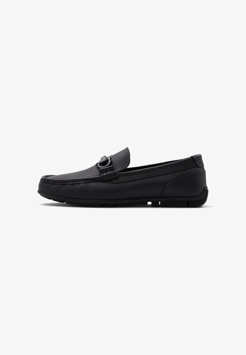 Black leather loafer, featuring a textured finish, decorative buckle, round toe, and flexible rubber sole for enhanced grip and comfort.