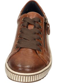 Sneaker en cuir brun avec des lacets bruns, fermeture éclair latérale et une semelle en caoutchouc texturée avec un design rayé. Doublure intérieure noire visible.