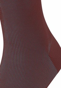 Braune, gerippte Socken mit strukturierter Oberfläche, die eine verstärkte Spitze und Ferse für Langlebigkeit aufweisen. Das Design beinhaltet dezente blaue Akzente.