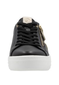 Baskets en cuir noir avec une semelle en caoutchouc blanc, dotées de lacets noirs et d'une fermeture éclair sur le côté avec quincaillerie dorée et une touche crème.