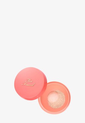 Runder, korallenfarbener Make-up-Behälter mit goldenem "Too Faced" Deckel und losem Puder mit gepresster Kuppel im Boden.
