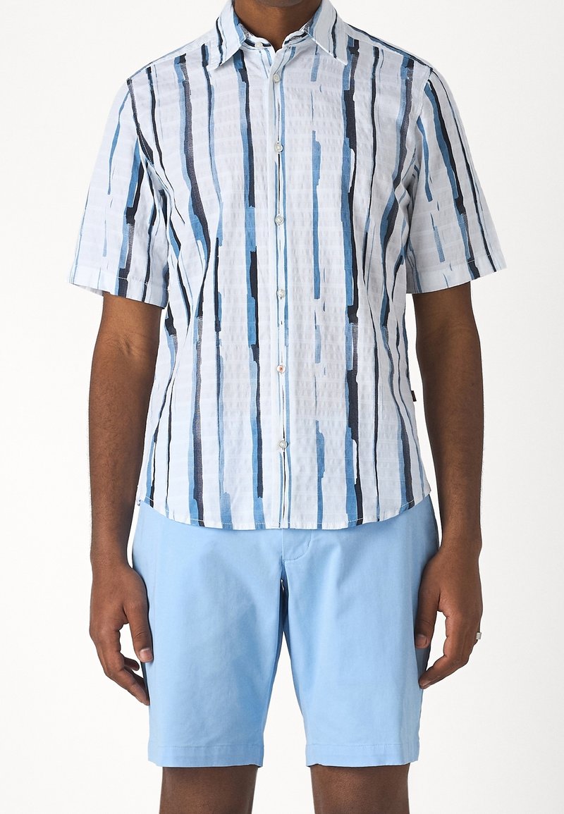Koszula z krótkim rękawem w pionowy wzór niebiesko-białych pasków, wykonana z lekkiego materiału, zestawiona z jasnoniebieskimi szortami, z przodu zapinana na guziki.
