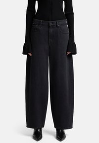 Zwart denim met wijde pijpen, een hoge taille en vijf zakken. Heeft donkere stiknaden en een knoop-ritssluiting. Gladde textuur.