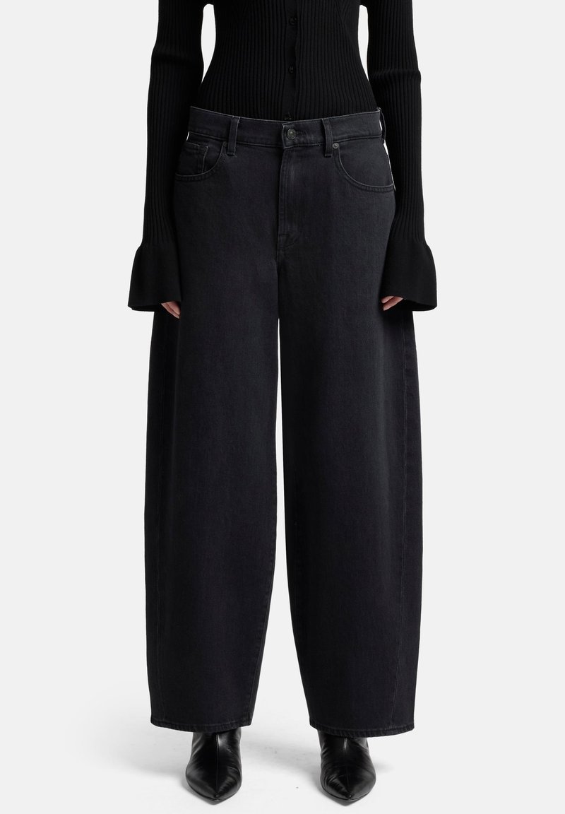 Zwart denim met wijde pijpen, een hoge taille en vijf zakken. Heeft donkere stiknaden en een knoop-ritssluiting. Gladde textuur.