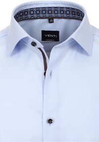 Světle modrá moderní pánská košile s button-down límečkem a květinovým vzorem uvnitř límce.