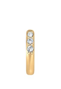 Pendiente de aro dorado con tres piedras de circonita cúbica claras y redondas engastadas en una banda lisa y pulida. Forma ovalada con un diseño elegante.