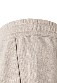 Béžové tepláky s elastickým pasem, texturovaná tkanina s melírovaným vzorem, s dvěma bočními sklady pro přidaný detail.