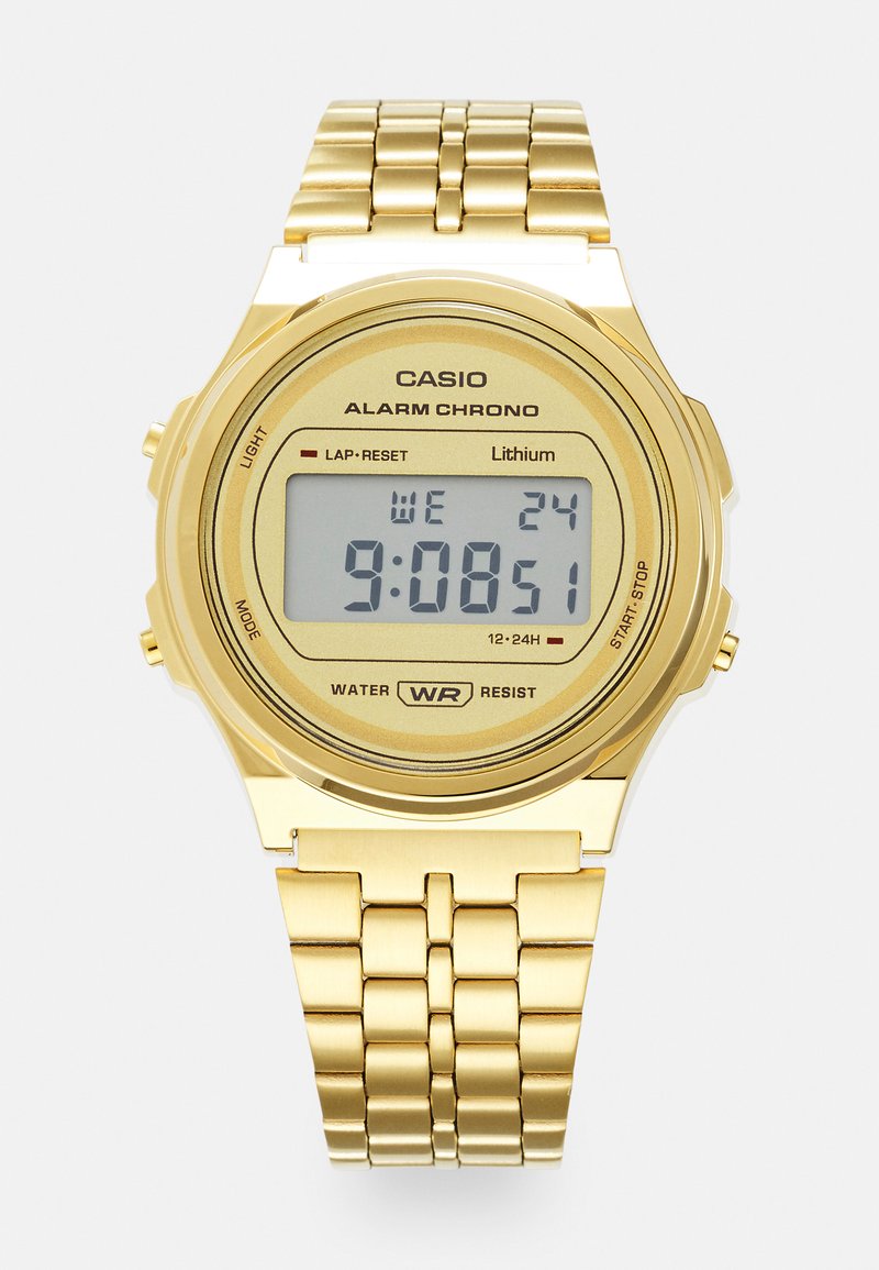 Montre digitale Casio dorée avec un cadran rectangulaire, un affichage numérique indiquant l'heure et la date, et un bracelet en maillons métalliques. Conception étanche.