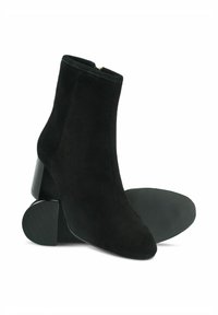 Czarne zamszowe botki za kostkę z ostrym noskiem, teksturowanym obcasem i gładkim zapięciem na zamek z tyłu. Gumowa podeszwa ze żłobieniami.