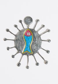 Colgante de metal plateado con una base circular texturizada, que presenta un vibrante diseño de pez azul con cabeza roja y contorno amarillo.
