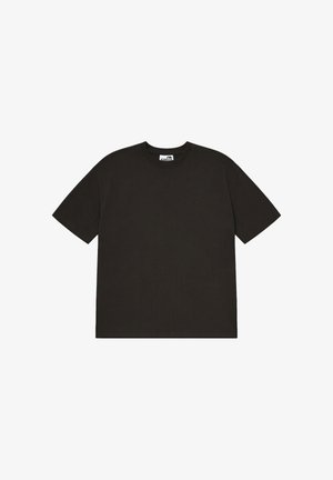 Czarna koszulka z krótkim rękawem i okrągłym dekoltem, luźnego kroju z widoczną metką przy szyi.