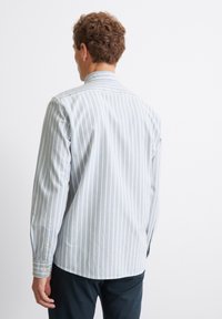 Camicia a maniche lunghe a righe blu chiaro con colletto a camicia, caratterizzata da un fit rilassato e polsini con bottone, realizzata in morbido cotone.