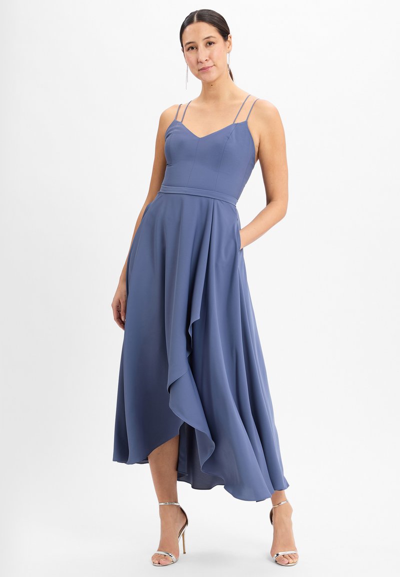 Weiches blaues, ärmelloses Kleid mit tailliertem Oberteil, asymmetrischem, fließendem Saum und seitlichen Taschen; aus leichtem Stoff gefertigt.