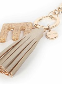 Portachiavi con un anello in metallo dorato, un tassello in finta pelle beige chiaro e un charm acrilico glitterato dorato a forma di "M".