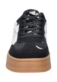 Zwarte en grijze suede sneakers met witte accenten, voorzien van een chunky tan zool en ronde veters. Inclusief een glanzend hiel-detail.