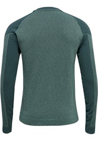 Vihreä pitkähihainen paita, jossa on teksturoitu selkäpuoli ja sileät hihat, raglan-saumalla ja pyöristetyllä helman lopulla.