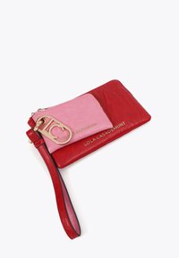 Červená a růžová kožená peněženka na zápěstí se zlatými kovovými detaily, kapsičkou na zip a potištěným logem značky. Hladký povrch, kompaktní obdélníkový design.