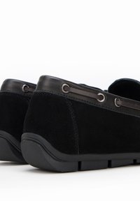 Zwarte glanzende suède schoenen met een glad leren bies, ronde neus, lage hak en decoratieve oogjes voor veters, met een flexibele rubberen zool.