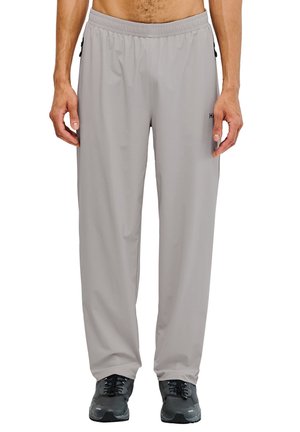 Hellgraue Sporthosen mit strukturiertem Material, elastischem Bund und Seitentaschen mit Reißverschluss. Getragen mit dunklen Turnschuhen.