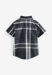Camicia a maniche corte con colletto di colore blu navy, decorata con un motivo a griglia di righe bianche e teal. Il tessuto ha una texture liscia e un orlo curvo.