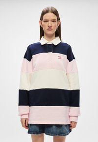 Μπλούζα πόλο με μακρύ μανίκι σε θαλασσί, ροζ και λευκό χρώμα με γιακά και λεπτομέρεια από κεντημένο λογότυπο στο στήθος, συνδυασμένη με τζην �φούστα.