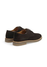 Chaussures en daim marron à lacets avec un bout rond, semelle beige contrastante et finition texturée, présentant un marquage minimal sur le côté.