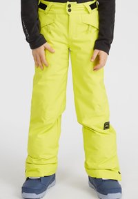 Pantaloni da sci giallo brillante con una texture liscia. Le caratteristiche includono ginocchia rinforzate, vita regolabile e un piccolo logo del marchio vicino all'orlo.