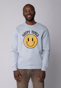 Helles blaues Sweatshirt mit einem großen gelben Smiley-Gesicht-Graphic und dem Text "HAPPY TIMES" darüber. Hergestellt aus weichem Baumwoll-Mischmaterial.