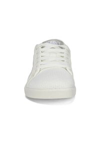 Vita sportskor med överdel i texturerad mesh, platt gummisula och traditionell snörning. Logotyp synlig på tungan.