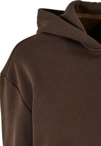 Brun hettegenser med myk tekstur, med snor i hetten og lett senket skuldre, som fanger et avslappet, moderne design.