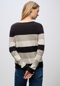 Sweter w paski w kolorach czarnym, beżowym i kremowym. Okrągły dekolt, długie rękawy, ściągacze na mankietach i luźny krój. Miękka dzianina.