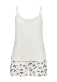 Witte tanktop met kantafwerking, gecombineerd met shorts met een zwart bladraster op een crèmekleurige achtergrond. Zachte stof en een relaxte pasvorm.