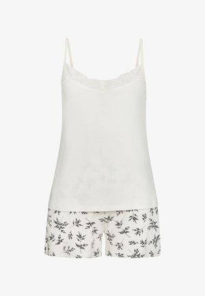 Camisola bianca con rifiniture in pizzo, abbinata a pantaloni corti con un motivo di foglie nere su sfondo crema. Tessuto morbido e vestibilità rilassata.