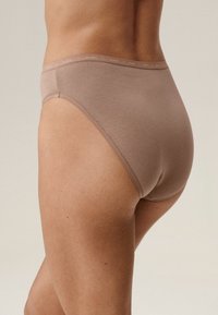 Beżowe bawełniane majtki z wysokim wycięciem i elastycznym pasem z nadrukowaną nazwą marki "ATLANTIC" w subtelnej kolorystyce. Gładka tekstura.