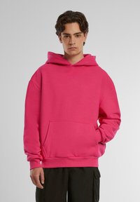 Hoodie rosa con un amplio bolsillo frontal, capucha con cordón y puños acanalados. Hecho de una tela suave con un corte relajado.