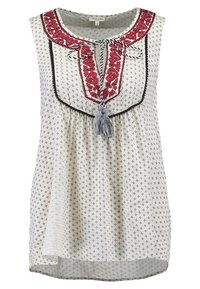 Vit ärmlös topp med röd broderad halsringning, svart kant, intrikata mönster och en tofsdetalj framtill. Avslappnad passform.