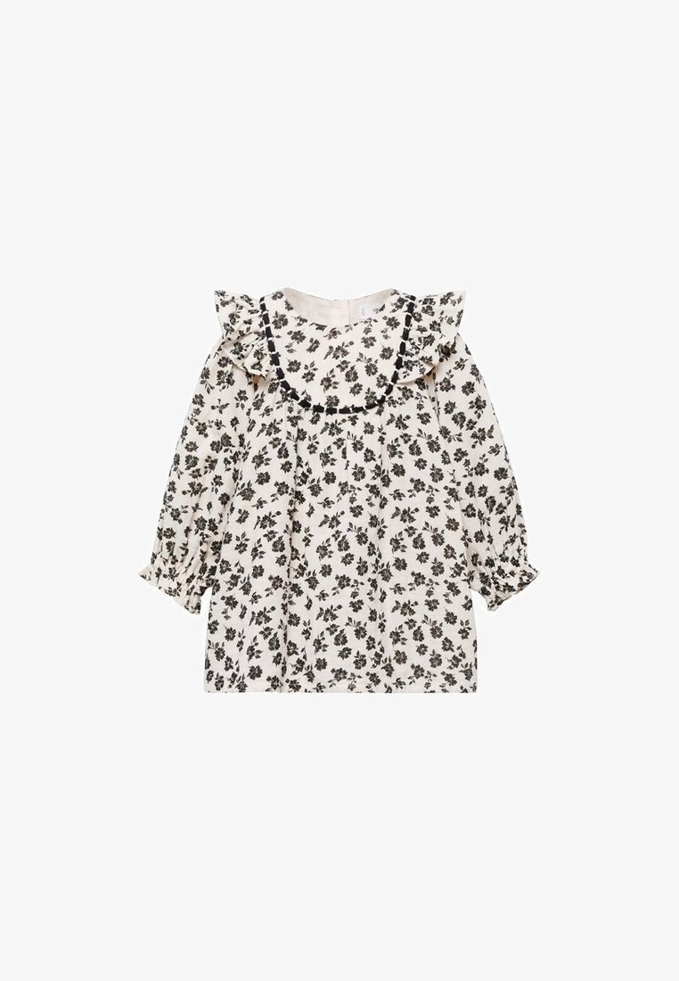 Blouse blanche à manches longues avec imprimé floral noir, col à volants et poignets froncés.