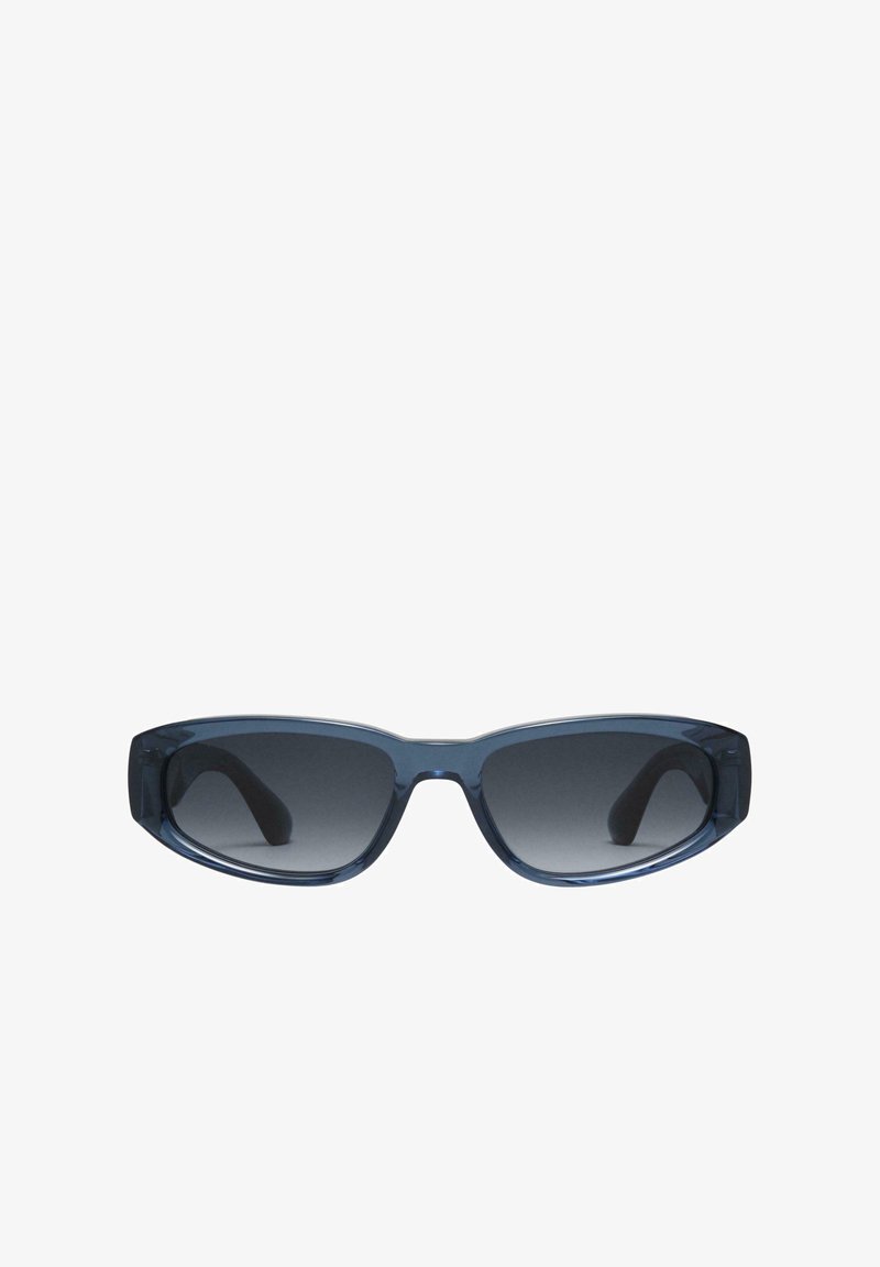 Kitsad kitsas ristkülikukujuline päikeseprillide raami, millel on tumedast hallist gradientprillid, läbipaistvast sinisest plastist raam ja veidi kõverad käed, et tagada kindel istuvus.