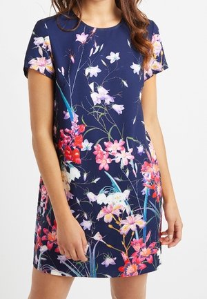 Abito floreale navy con maniche corte, fiori rosa e bianchi vivaci, e una silhouette aderente con una texture di tessuto liscia.