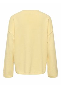 Haut à manches longues jaune avec une coupe décontractée, un col rond et des épaules tombantes. Tissu doux et texturé de couleur unie. Pas de motifs ni d'ornements.