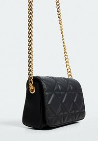 Czarna pikowana torba na ramię ze złotym łańcuszkiem. Charakteryzuje się geometrycznymi wzorami na powierzchni oraz kompaktowym designem.