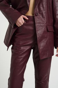 Burgundy faux leather outfit with a textured, mock-croc pattern; features a blazer with a single button and wide lapels, and fitted pants.