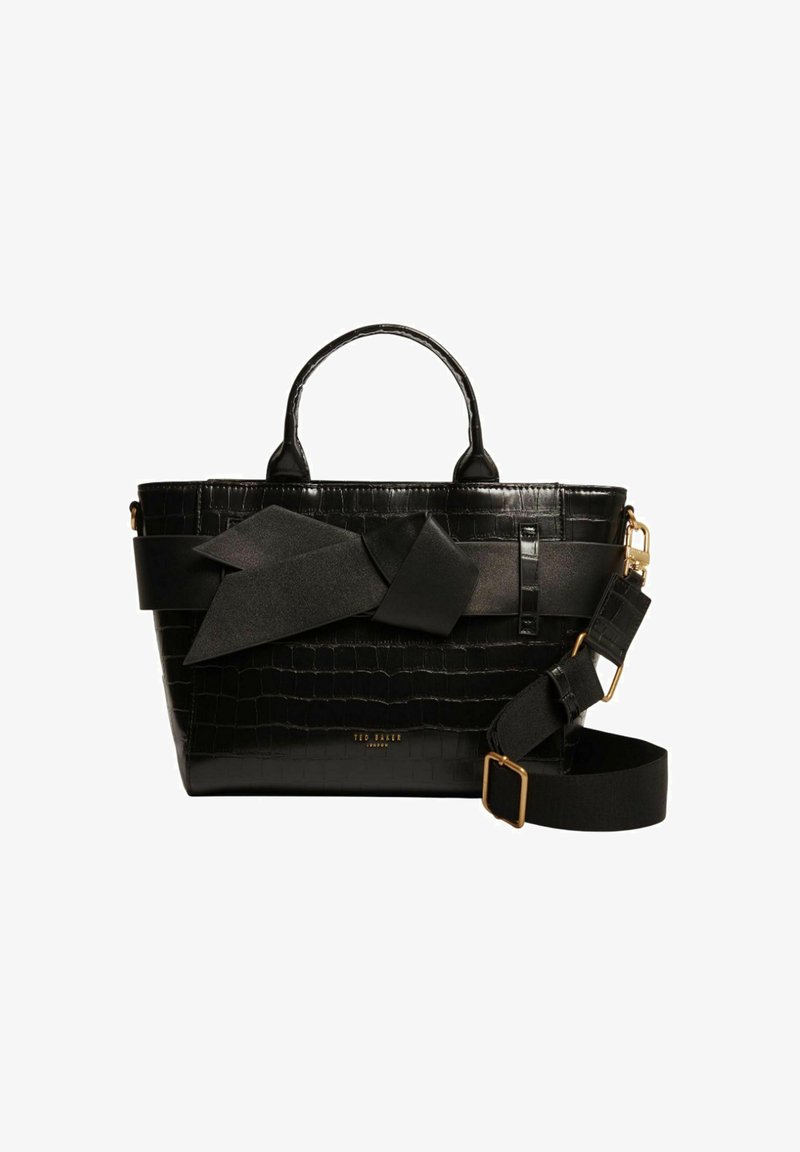 Sac en cuir noir embossé crocodile avec double anses, un grand accent en forme de nœud, une bandoulière réglable et des détails en métal doré.